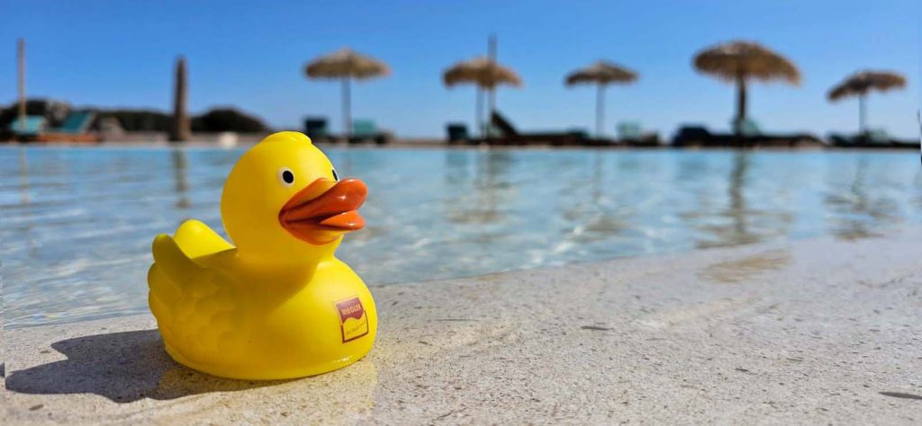 Riegler Badeente an einem Pool mit Sonnenschrimen